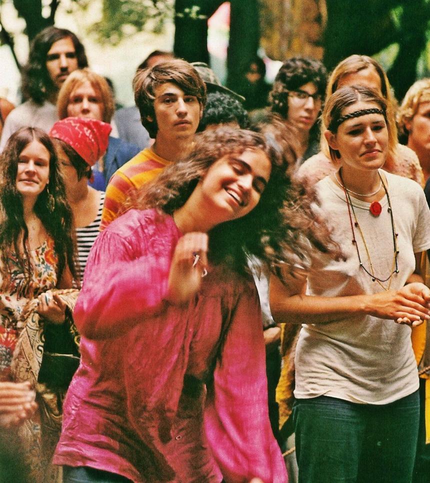 The aesthetic deliberately rejects mid-20th-century formal dress codes like suits and ties. Instead, it favors loose, comfortable clothing in natural hues, long hair, and accessories such as circular sunglasses. These choices symbolize nonconformity.